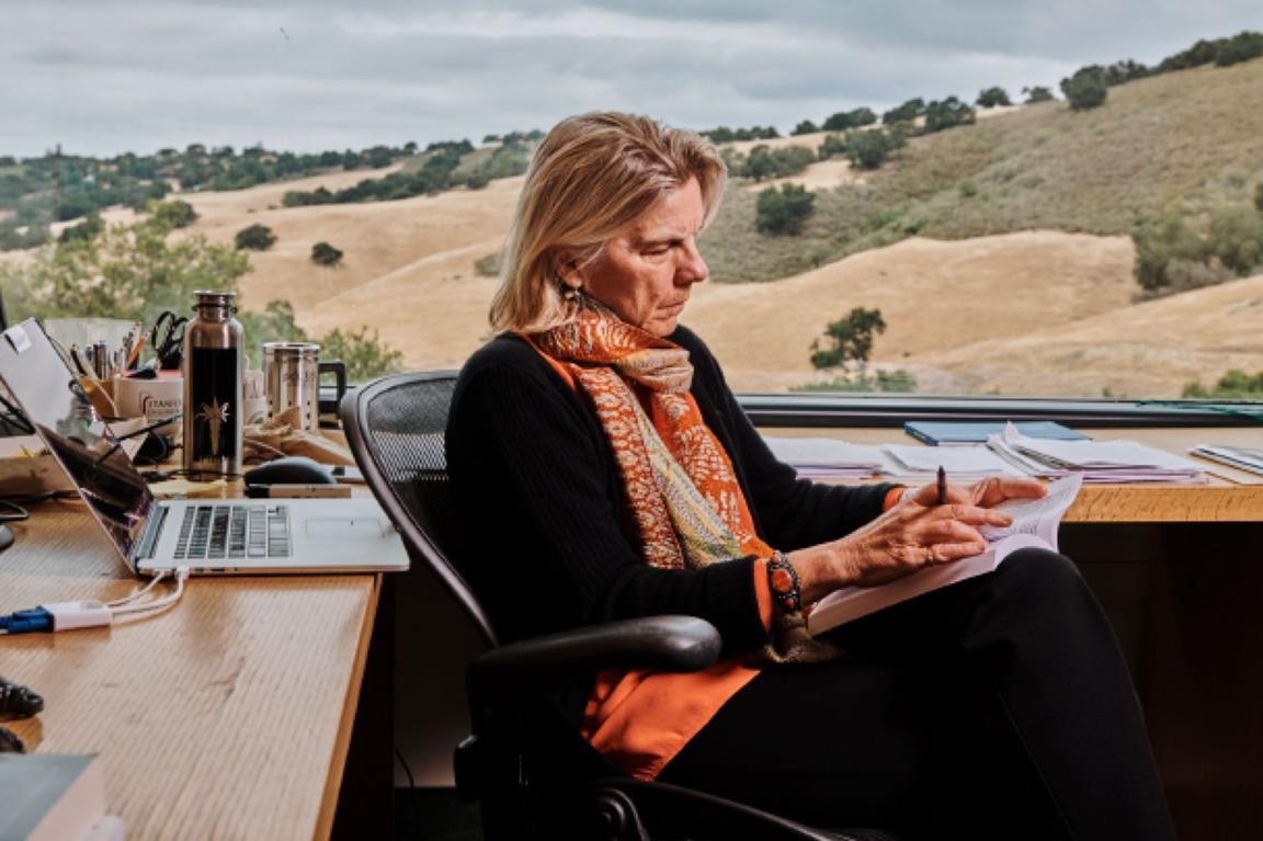 person working at desk with open field out window